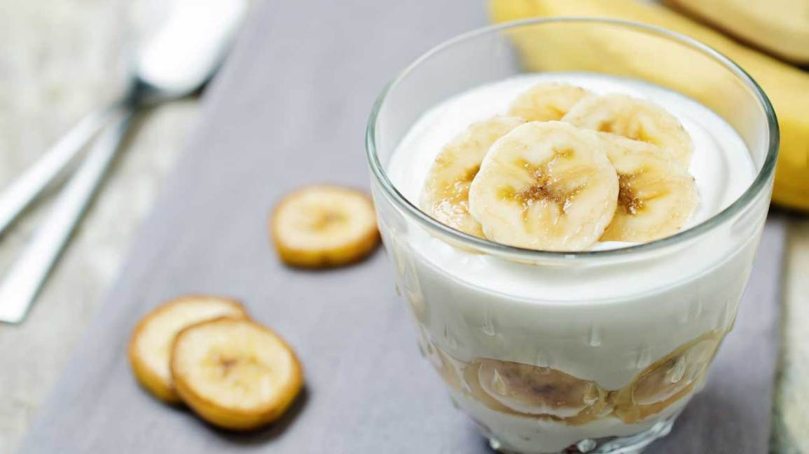greek yogurt in a glass with banana slices on top